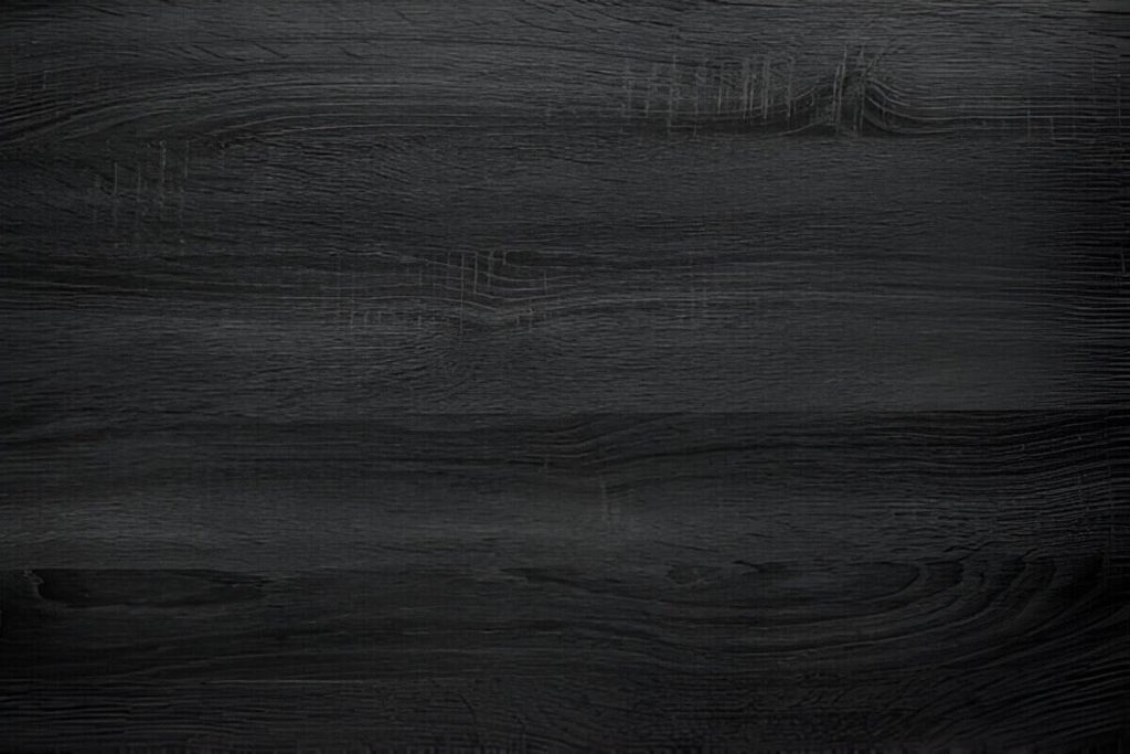 Black wood stain finish close up showing a deep dramatic tone and visible grain beneath the dark surface