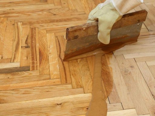 Applying hardwood floor stain on a parquet floor during refinishing