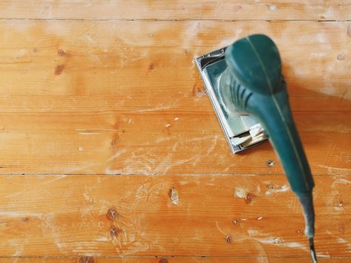Hardwood floor surface being sanded during prep work to remove wear and prepare for refinishing