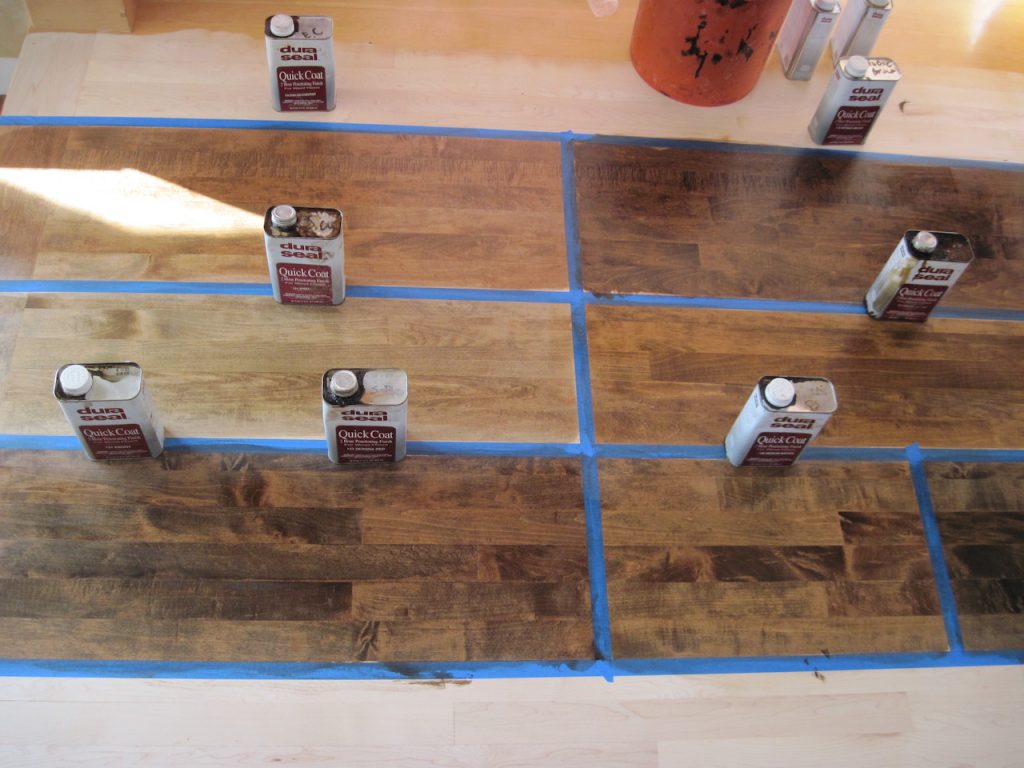 Hardwood floor stain color samples tested on wood boards before choosing a final stain