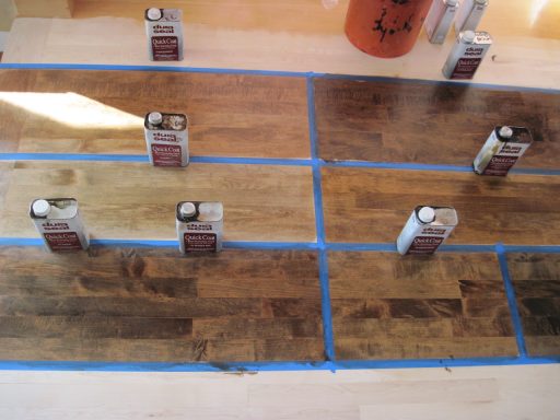 Hardwood floor stain color samples tested on wood boards before choosing a final stain