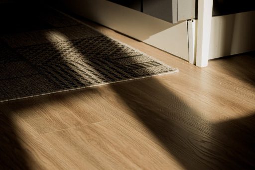 Rug on hardwood floor near entry showing a simple way to reduce friction wear and help limit floor squeaks
