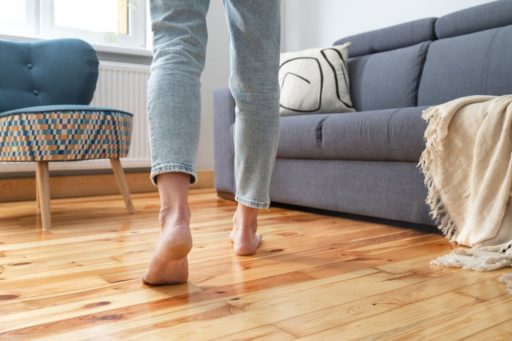 Walking barefoot on hardwood floor showing everyday foot traffic that can reveal squeaks or movement underfoot