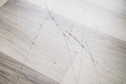 Deep scratches on wood floor close up showing damage that may cut through the finish into the wood