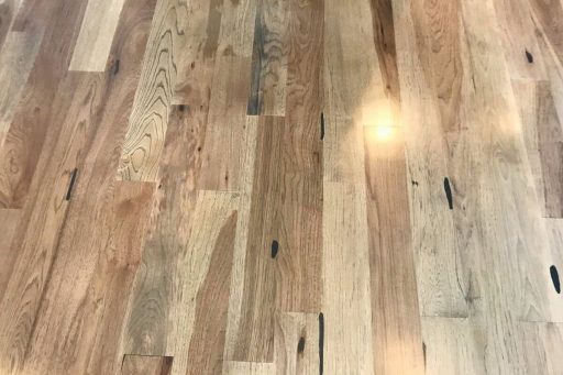 Cabin grade hardwood flooring with mineral streaks, knots, and natural color variation