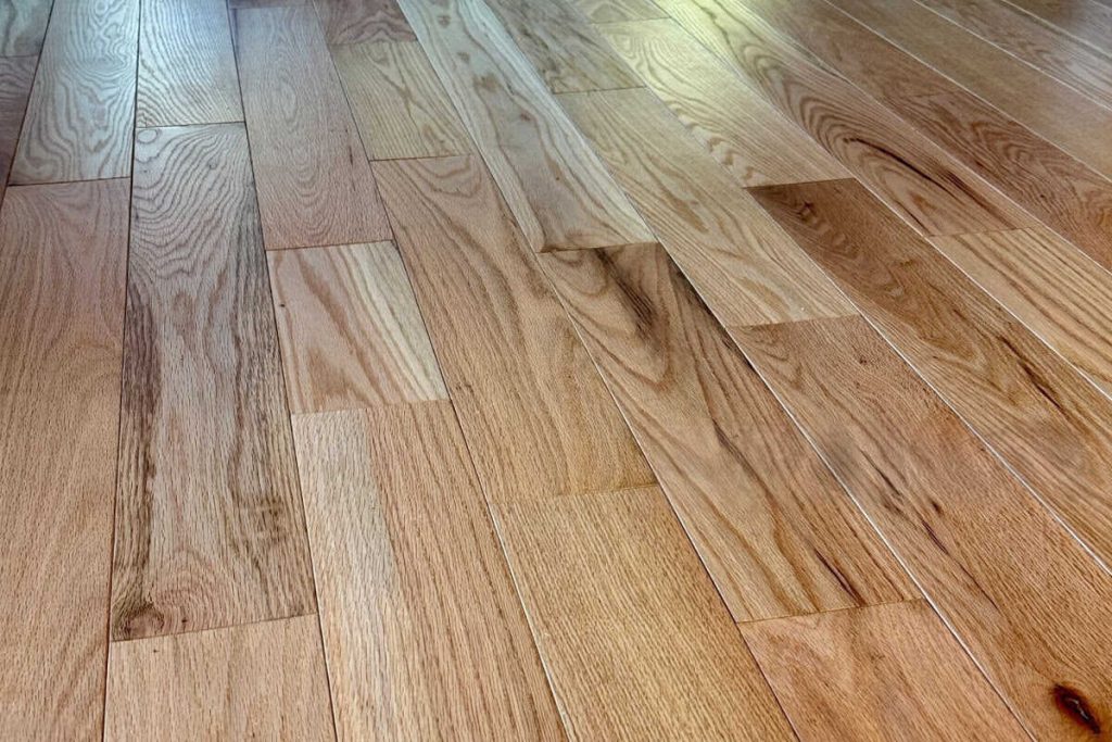 Cabin grade hardwood flooring with visible color variation, grain contrast, and natural character marks