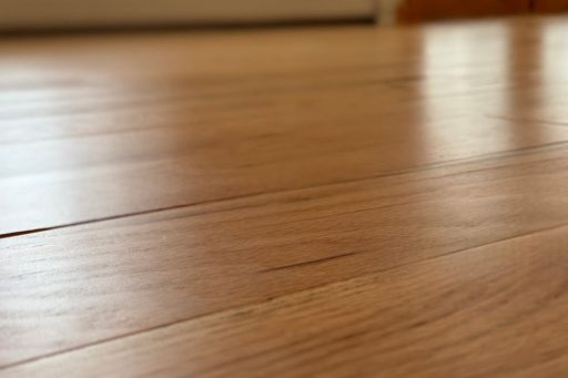 Wide view of hardwood floor showing thin seasonal gaps between planks