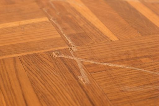 Deep sanding marks and scratches on hardwood floor from improper sanding