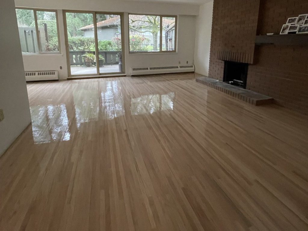 Hardwood floor finish after refinishing with a smooth protective coat in a large living room