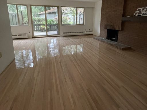 Hardwood floor finish after refinishing with a smooth protective coat in a large living room