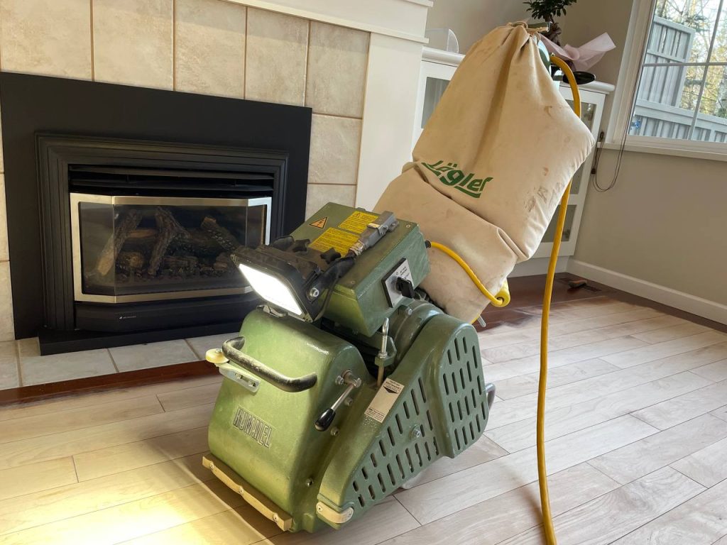 Hardwood floor sanding machine with attached dust bag for dust collection during floor refinishing