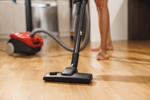 Vacuuming hardwood floor to remove dust and debris before cleaning